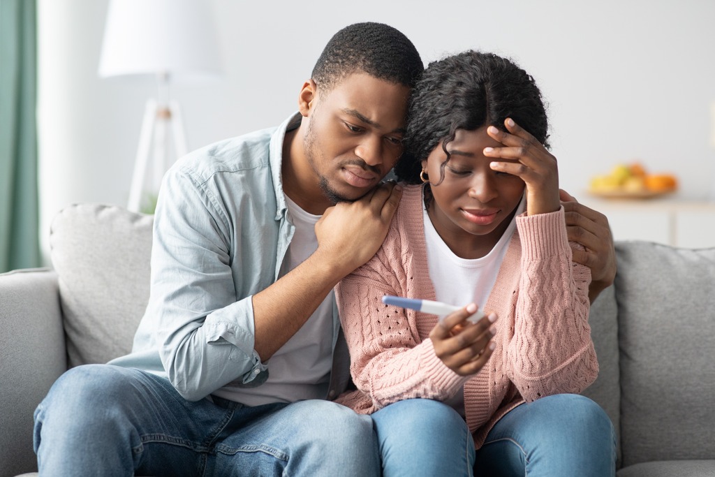 Depressed African-American Couple With Pregnancy Test Know It’s Time to See a Doctor for Infertility