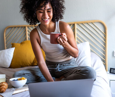 A Woman Smiling At Her Laptop Screen At Ease While Researching What Is A Laparoscopy