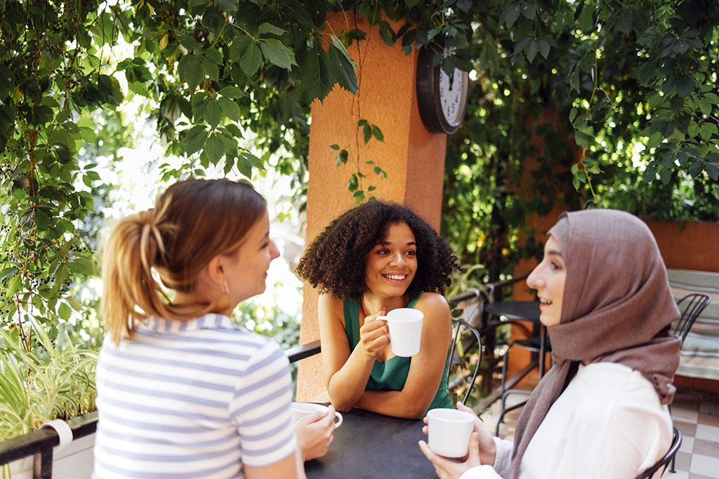 A Group Of Girls Sitting At A Table Drinking Coffee & Talking About Sonohysterogram.