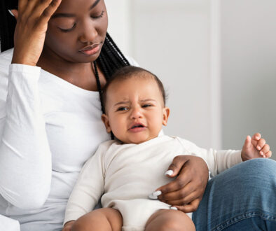 A New Mother With Her Crying Baby Sitting In Her Lap You're Postpartum, Now What?