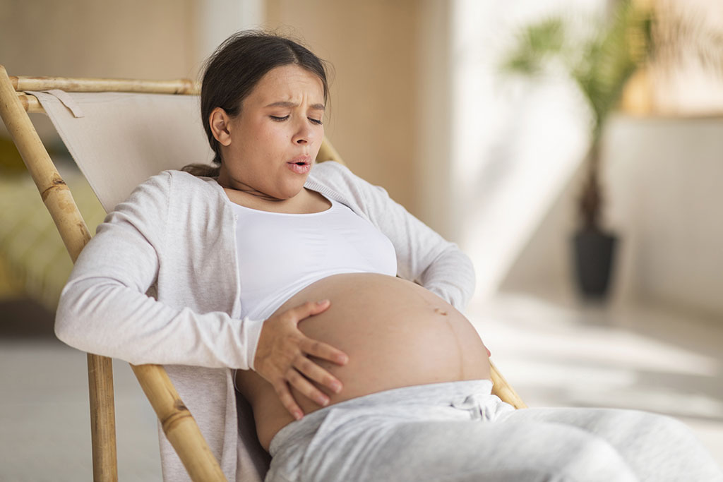 Latin American Woman Holding Her Pregnant Belly in Pain Fibroids and Pregnancy