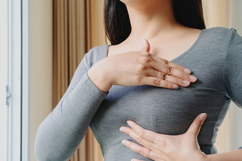 Closeup Of A Woman Using Her Hands To Check For Breast Lumps During A Self-Breast Exam
